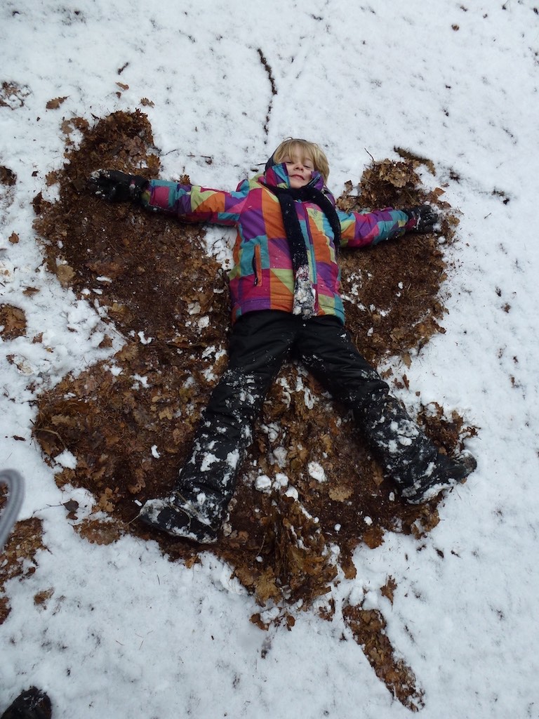 Kind macht Engel im Schnee